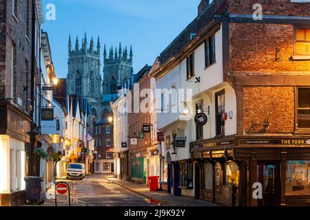 Morgendämmerung auf Low Petergate in York. Die Türme des York Minster in der Ferne. Stockfoto