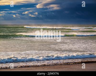 Windgepeitschte Wellen mit drohenden Sturmwolken am Horizont Stockfoto