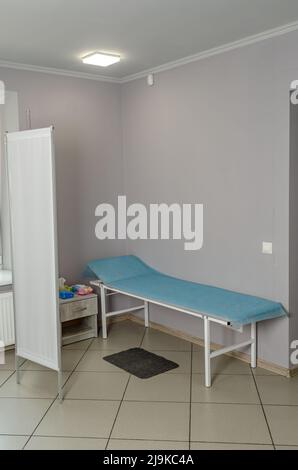 Moderner Raum in der Klinik für die Untersuchung und Behandlung von Patienten. Medizinische Couch. Sieb, Einweglaken Stockfoto