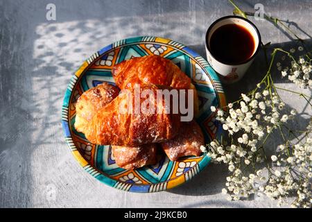 Süßer Morgen. Nahaufnahme von kleinen Croissants auf einem Teller. Stillleben. Stockfoto