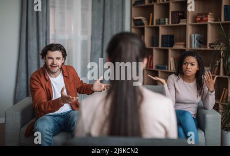 Unzufriedene, wütende, tausendjährige afroamerikanische Dame und europäischer Mann streiten und brüllen Stockfoto