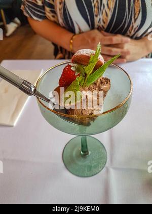 Köstliches Luxus-Schokoladenmousse mit Minze und Erdbeere, serviert in einem Luxusglas in einem Bistro-Restaurant Stockfoto