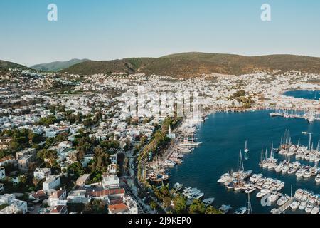 Luftlandschaft von weißen Villen in Bodrum Türkei während des Sonnenuntergangs um einen großen Yachthafen voller Segelboote und Yachten Stockfoto