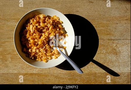 Schüssel mit knusprigen Nussflocken auf verwitterter Tischplatte Stockfoto