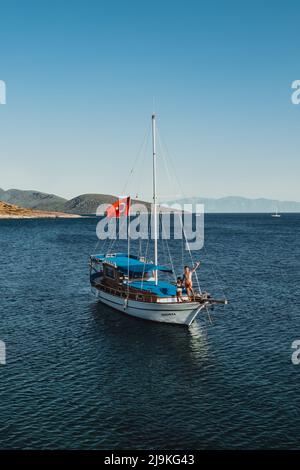 Luftbild eines türkischen Segelbootes, das im Hafen auf einer Insel in der Nähe von Bodrum Türkei während des Sonnenuntergangs im Mittelmeer verankert ist Stockfoto
