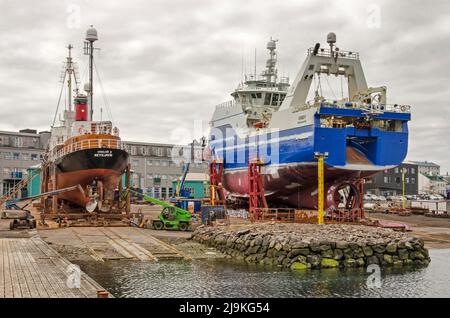 Stykkisholmur, Island, 3. Mai 2022: Zwei Schiffe zur Reparatur in einer Werft im alten Hafen der Stadt Stockfoto