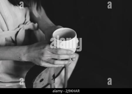 Foto eines Keramikbechers in der Nahaufnahme der weiblichen Hände Stockfoto