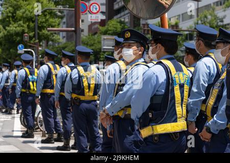 Tokio, Japan. 24.. Mai 2022. Polizeibeamte bereiten sich darauf vor, die Sicherheit einer kleinen Gruppe von Demonstranten im Zentrum von Tokio in der Nähe des Bahnhofs Ichigaya zu gewährleisten. Eine kleine Gruppe von rund 100 Demonstranten versammelte sich im Zentrum Tokios, um gegen das Quad Leaders' Meeting 2022 zu protestieren und ihre Meinung über den anhaltenden Krieg in der Ukraine auszudrücken, der Russland, die USA und die NATO kritisiert. Sie riefen auch den japanischen Premierminister Fumio Kishida zum Abtritt sowie den US-Präsidenten Joe Biden auf. Kredit: SOPA Images Limited/Alamy Live Nachrichten Stockfoto