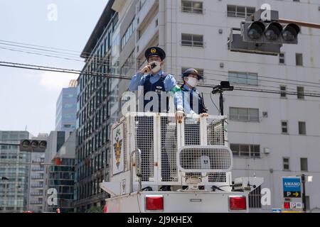 Tokio, Japan. 24.. Mai 2022. Der Polizeibeamte informiert die Öffentlichkeit von oben auf einem Polizeiwagen über eine nahende Demonstration. Eine kleine Gruppe von rund 100 Demonstranten versammelte sich im Zentrum Tokios, um gegen das Quad Leaders' Meeting 2022 zu protestieren und ihre Meinung über den anhaltenden Krieg in der Ukraine auszudrücken, der Russland, die USA und die NATO kritisiert. Sie riefen auch den japanischen Premierminister Fumio Kishida zum Abtritt sowie den US-Präsidenten Joe Biden auf. Kredit: SOPA Images Limited/Alamy Live Nachrichten Stockfoto