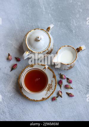 Tee mit Rosen Nahaufnahme Foto. Kräutertee in einer kleinen weißen Keramikschale auf einem Tisch. Hellgrauer Hintergrund mit Kopierbereich. Stockfoto