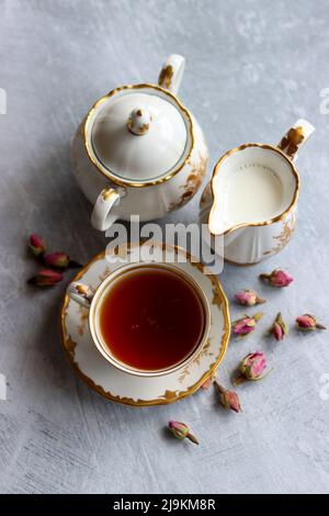 Tee mit Rosen Nahaufnahme Foto. Kräutertee in einer kleinen weißen Keramikschale auf einem Tisch. Hellgrauer Hintergrund mit Kopierbereich. Stockfoto