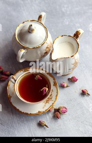 Tee mit Rosen Nahaufnahme Foto. Kräutertee in einer kleinen weißen Keramikschale auf einem Tisch. Hellgrauer Hintergrund mit Kopierbereich. Stockfoto