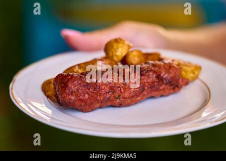 Preparing meat rolls called mici or mititei on barbecue. close up of grill with burning fire with flame and smoke. Stock Photo