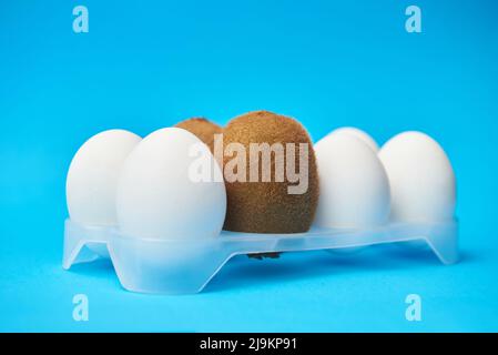 Haarige Kiwi zwischen glatten Eiern, Konzept der männlichen Enthaarung Stockfoto