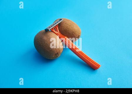 Haarige Kiwi und Rasiermesser, Konzept der männlichen Enthaarung Stockfoto