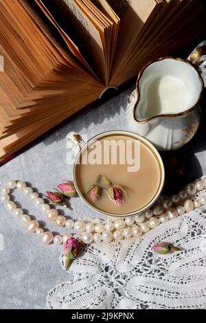 Tee mit Rosen Nahaufnahme Foto. Kräutertee in einer kleinen weißen Keramikschale auf einem Tisch. Hellgrauer Hintergrund mit Kopierbereich. Stockfoto