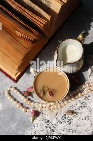 Tee mit Rosen Nahaufnahme Foto. Kräutertee in einer kleinen weißen Keramikschale auf einem Tisch. Hellgrauer Hintergrund mit Kopierbereich. Stockfoto