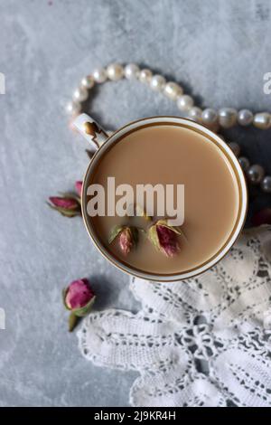 Tee mit Rosen Nahaufnahme Foto. Kräutertee in einer kleinen weißen Keramikschale auf einem Tisch. Hellgrauer Hintergrund mit Kopierbereich. Stockfoto