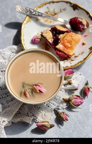 Tee mit Rosen Nahaufnahme Foto. Kräutertee in einer kleinen weißen Keramikschale auf einem Tisch. Hellgrauer Hintergrund mit Kopierbereich. Stockfoto