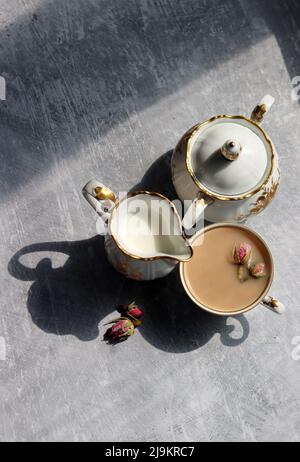 Tee mit Rosen Nahaufnahme Foto. Kräutertee in einer kleinen weißen Keramikschale auf einem Tisch. Hellgrauer Hintergrund mit Kopierbereich. Stockfoto