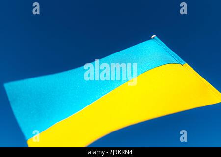 Große zweifarbige gelb-blaue ukrainische Staatsflagge, nationales Symbol flattert, winkt im Wind gegen den blauen Himmel an sonnigen Tagen. Kiew, Hauptstadt der Ukraine, Tag der Unabhängigkeitsverfassung, Nationalfeiertag Stockfoto