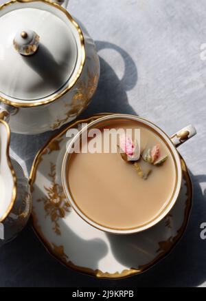 Tee mit Rosen Nahaufnahme Foto. Kräutertee in einer kleinen weißen Keramikschale auf einem Tisch. Hellgrauer Hintergrund mit Kopierbereich. Stockfoto