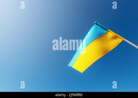 Große zweifarbige gelb-blaue ukrainische Staatsflagge, nationales Symbol flattert, winkt im Wind gegen den blauen Himmel an sonnigen Tagen. Kiew, Hauptstadt der Ukraine, Tag der Unabhängigkeitsverfassung, Nationalfeiertag Stockfoto