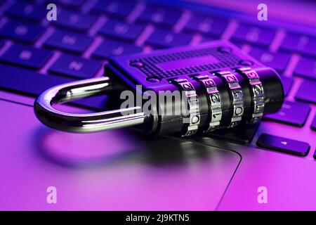 Schutzkonzept für die Computersicherheit. Geschlossenes Vorhängeschloss am Laptop mit farbenfrohen Lichtern Stockfoto