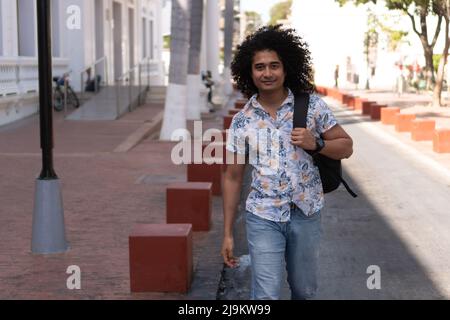 Afroamerikanische College-Studentin, mit Rucksack, die Straße hinunter. Stockfoto