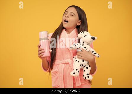 Kindheit Glück. Guten Morgen. Sleepy Kind tragen Nachthemd spielen mit Spielzeug. Kind in gemütlichen Schlafbekleidung. Stockfoto