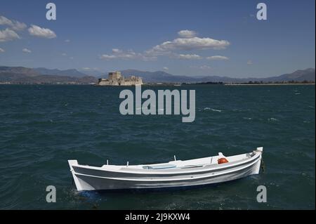 Landschaft mit Panoramablick auf ein griechisches Fischerboot und Bourtzi, die venezianische Festung im Renaissance-Stil und das historische Wahrzeichen von Nafplio in Griechenland. Stockfoto