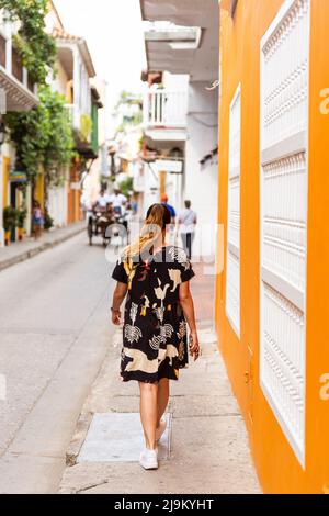 Rückansicht einer Latina-Frau, die im historischen Zentrum von Cartagena in Kolumbien spazierengeht Stockfoto
