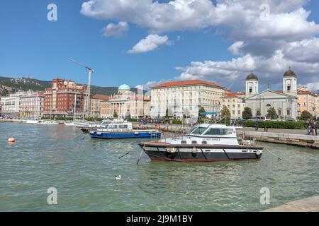 Boote, die an der Strandpromenade (Riva Tre Novembre) von Molo Audace aus gesehen werden - ein 200m Steinpier im aquamarinen Adriatischen Meer, Golf von Triest, Triest, Italien Stockfoto