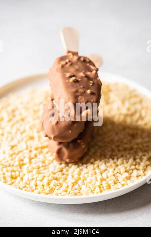 Drei Mandel-Vanille-Eis auf einem Stock mit Schokoladenglasur. Stockfoto
