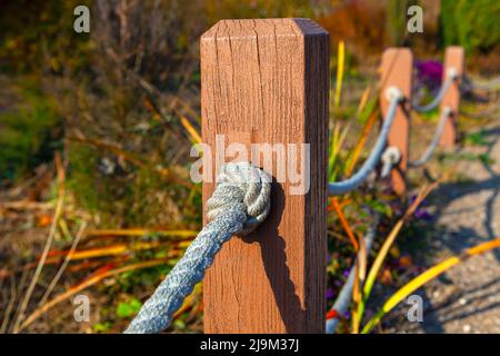 Zaun mit Seil und Holzsäulen Stockfoto