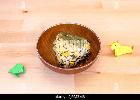 Onigiri oder Omusubi ist ein japanisches Gericht, das aus einer Reiskugel besteht, die mit anderen Zutaten gefüllt ist Stockfoto