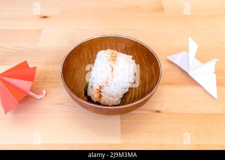 Onigiri oder Omusubi ist ein japanisches Gericht, das aus einer Reiskugel besteht, die mit anderen Zutaten gefüllt ist Stockfoto