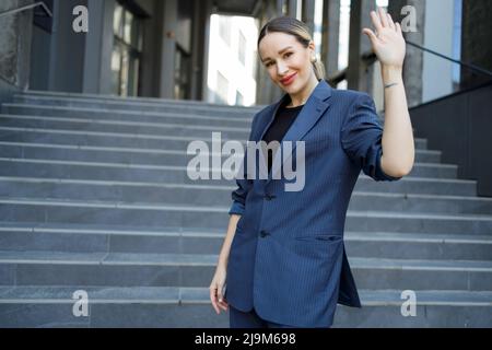 Geschäftsfrau winkt mit der Hand im Freien Stockfoto