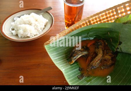 Wels in Chilisauce mit Bananenblatt-Basis. Traditionelle Dorfgerichte aus Indonesien. Reisgericht mit Wels Stockfoto