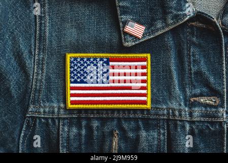 Alles gute zum Unabhängigkeitstag Juli 4.. Textilpatch mit amerikanischer Flagge auf einer Denim-Jacke und American Pin. Wir feiern das Konzept des Unabhängigkeitstages Stockfoto