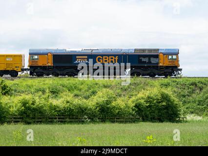 GBRf-Diesellokomotive der Klasse 66 Nr. 66748 'West Burton 50' mit einem Zug der Network Rail, Warwickshire, Großbritannien Stockfoto