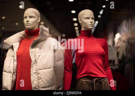 Mannequins in Kleidung. Mann und Frau in roten Jacken. Modevorführung. Details zum Shop-Fenster. Stockfoto