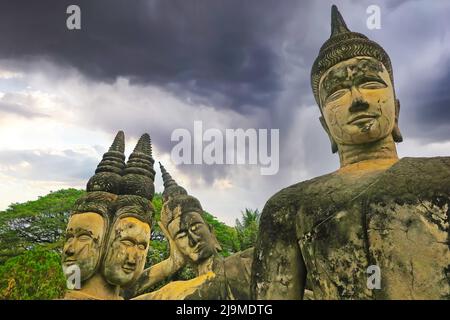 Mystische 4 Stein buddha Köpfe Statuen, dunkle Sturmwolken - Buddha Park (Wat Xieng Khuan), Vientiane, Laos Stockfoto