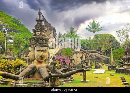 Mystischer tropischer Garten mit hinduistischen und buddhistischen mythologischen Kreaturen Steinskulpturen, Sturmwolken - Buddha Park (Wat Xieng Khuan), Vientiane, Laos Stockfoto