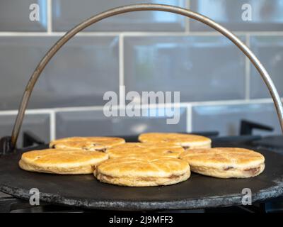 Ausgewählte FOCUS Welsh Cakes kochen auf einem gusseisernen Grill über einer Gaskochflamme Stockfoto