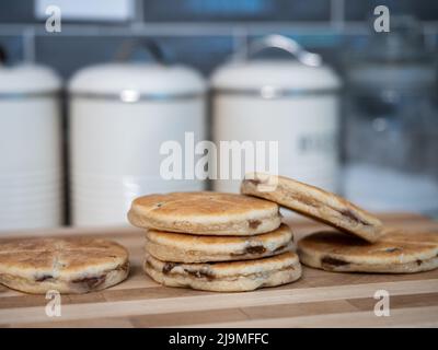 Heiße walisische Kuchen kühlen auf einem Holzbrett in der Küche Stockfoto