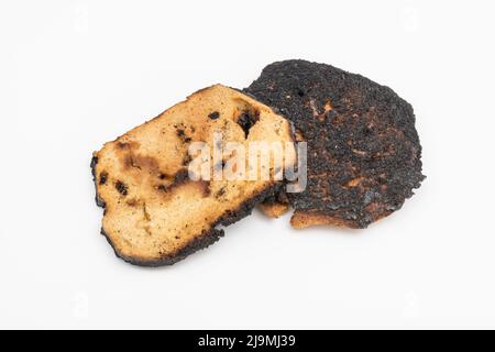 Brot, das auf einer Seite verkocht und zu einer Zünette verbrannt wurde. Bei Acrylamid und Krebs, Lebensmittel ungenügend zum Essen, schlechte Küchenkenntnisse, nicht in der Lage zu kochen. Stockfoto