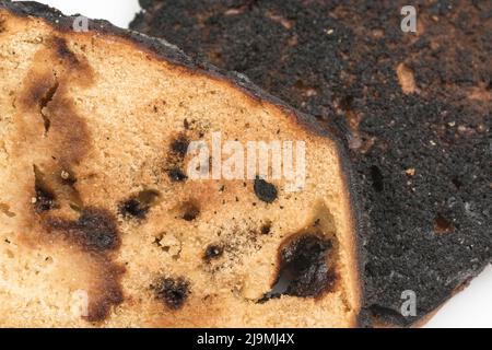 Brot, das auf einer Seite verkocht und zu einer Zünette verbrannt wurde. Bei Acrylamid und Krebs, Lebensmittel ungenügend zum Essen, schlechte Küchenkenntnisse, nicht in der Lage zu kochen. Stockfoto