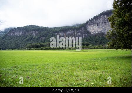 Panoramablick auf Reichenbach fällt auf Berge mit Blick auf die saftig grünen Wiesen aus dem Dorf Meiringen, Schweiz Stockfoto