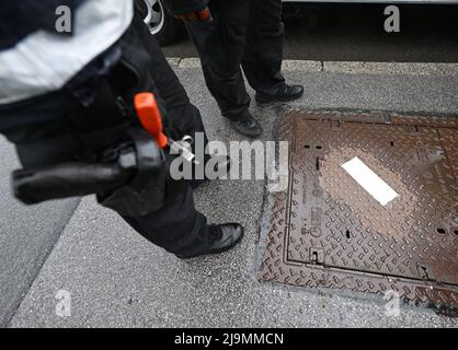 Garmisch Partenkirchen, Deutschland. 24.. Mai 2022. Polizeibeamte stehen neben einer Schachtabdeckung auf der Protokollroute, die aus Sicherheitsgründen versiegelt wurde. Der Gipfel G7 findet vom 26. Bis 28. Juni 2022 auf Schloss Elmau statt. Quelle: Angelika Warmuth/dpa/Alamy Live News Stockfoto